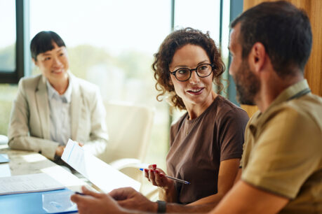 Man and woman discussing documents while sitting with advisor