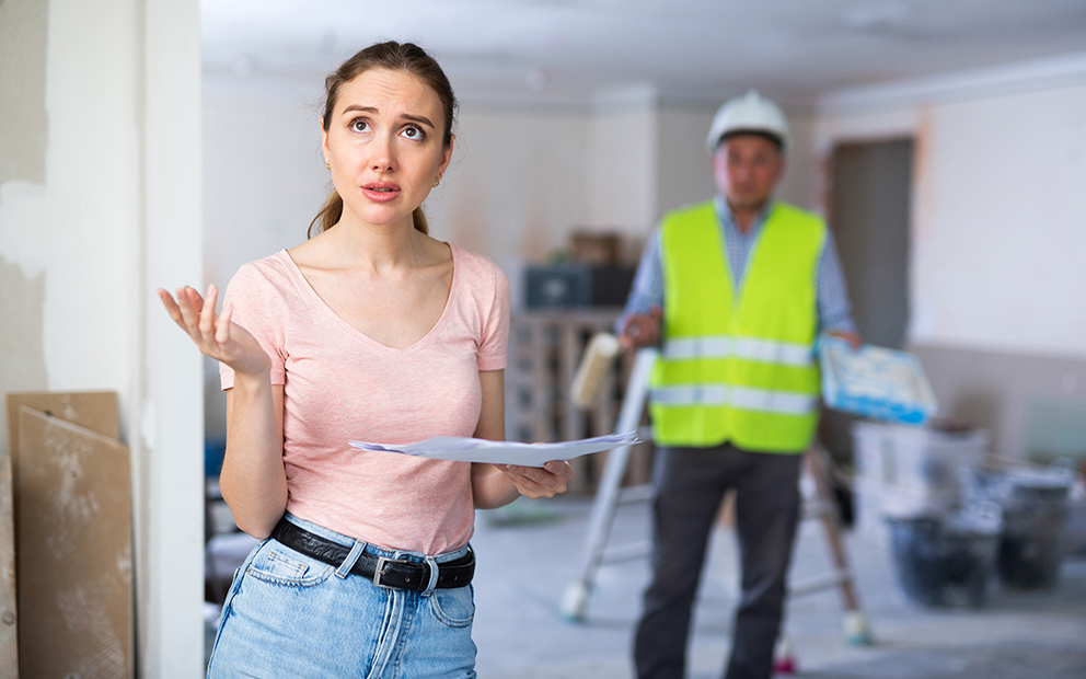 woman looking stressed with contractor in background