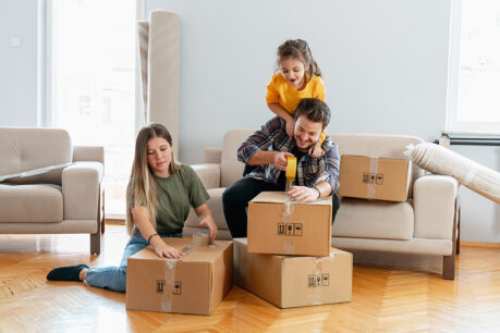 Family laughing and playing while packing up living room