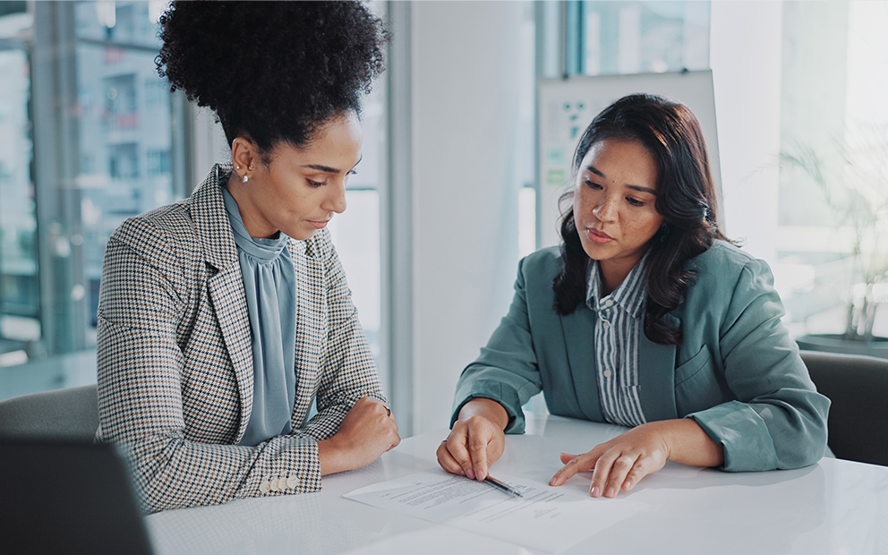 Woman speaking with advisor as they review documents together
