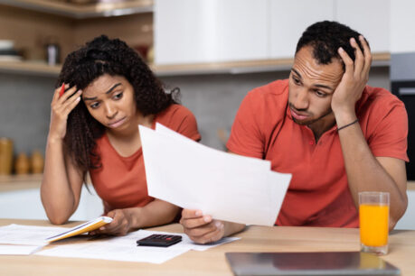 Couple looking stressed while reviewing documents