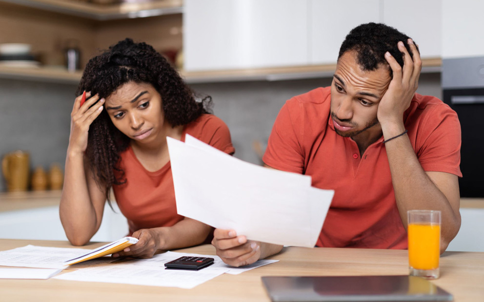 Couple looking stressed while reviewing documents