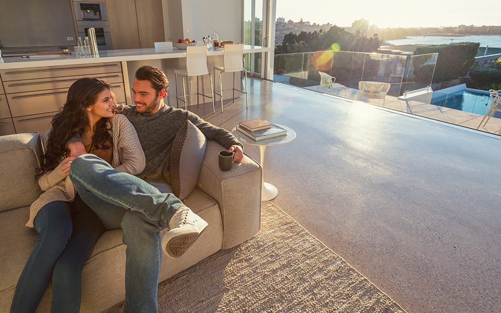 Man and woman sitting together on couch inside new condo