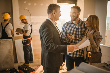 Couple talking to realtor in home while it is under construction