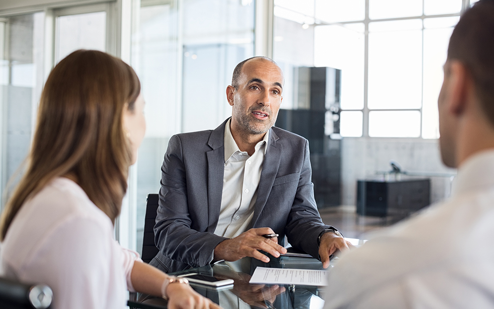 Couple speaking with advisor in office