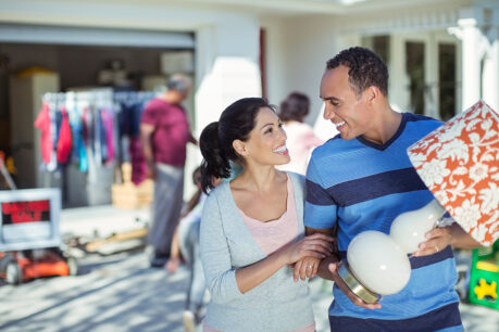 Couple outside home while they enjoy their yard sale