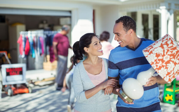 Couple outside home while they enjoy their yard sale