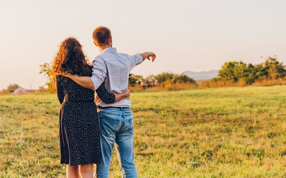 Couple looking out at open land and talking