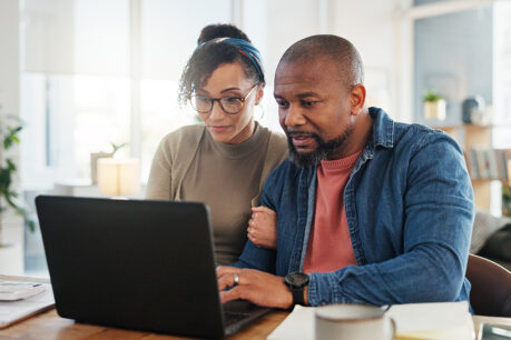 Couple looking at finance documents on laptop