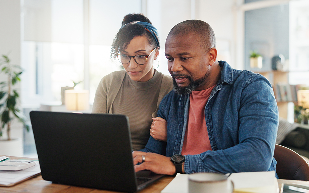 Couple looking at finance documents on laptop
