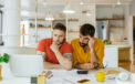 Couple with confused facial expressions as they look at documents