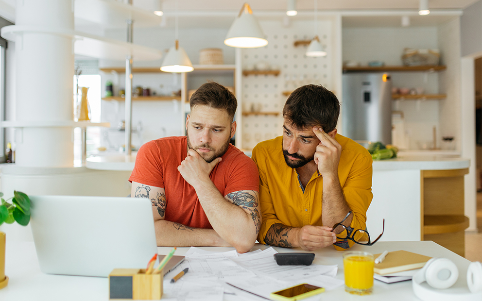 Couple with confused facial expressions as they look at documents