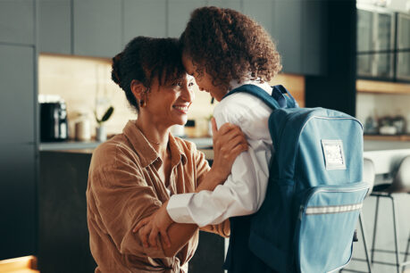 Mom smiling with daughter before leaving home for school