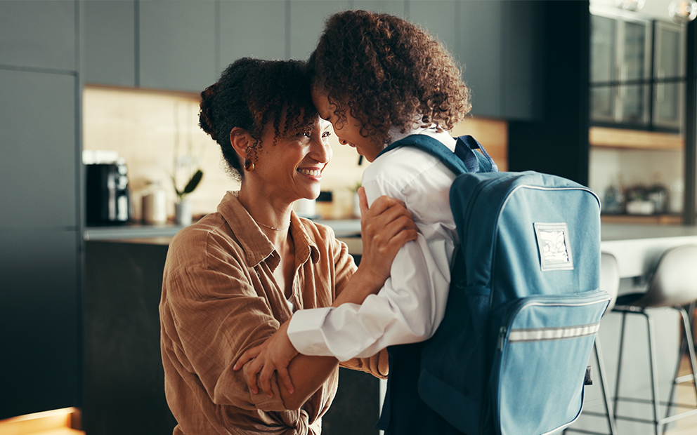 Mom smiling with daughter before leaving home for school