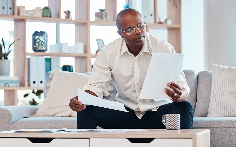Man reviewing documents and research at home table