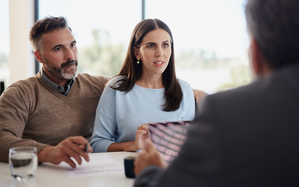 Couple speaking with advisor in office