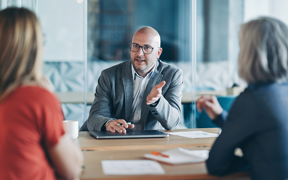 Two women listening to advisor from across a desk