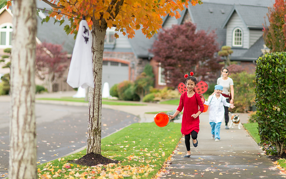 Woman accompanying her two children as they trick or treat