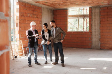 Couple speaking with builder in new property