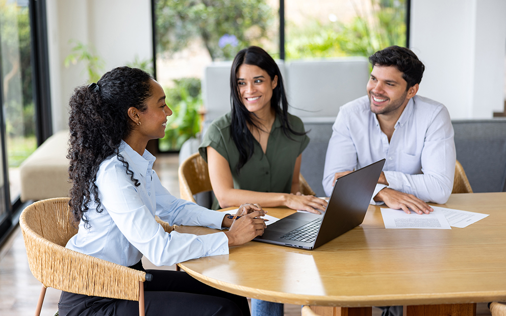 Couple smiling and discussing with agent at home
