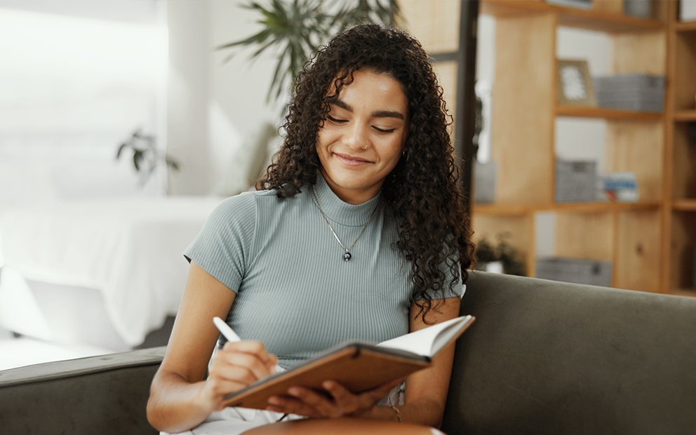 Woman taking notes will sitting at home
