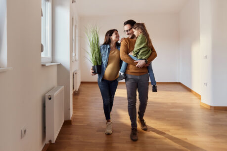 Family of three walking through new home