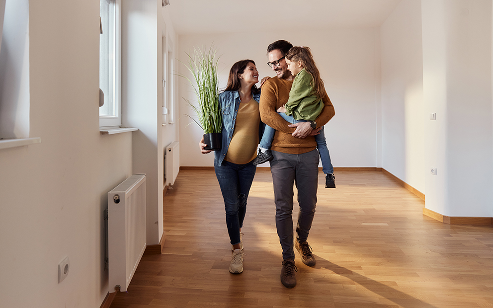 Family of three walking through new home
