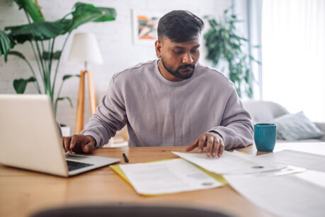 Man reviewing documents at home desk