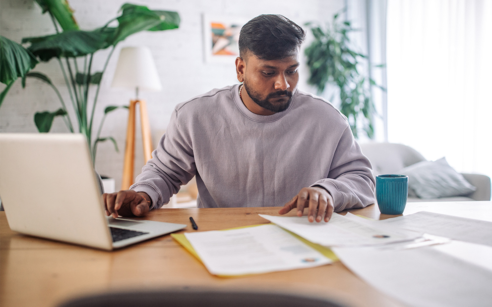 Man reviewing documents at home desk