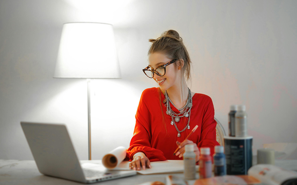 Woman smiling while researching on laptop