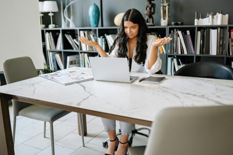 Woman shocked and confused while looking at computer