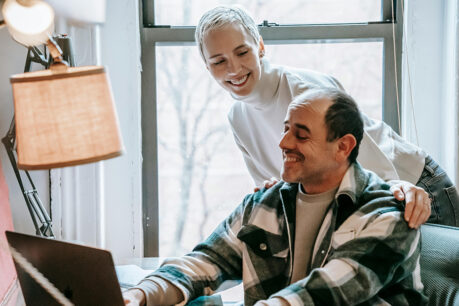 Wife helping husband research on computer
