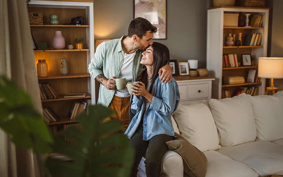 Couple embracing and smiling together while in new home