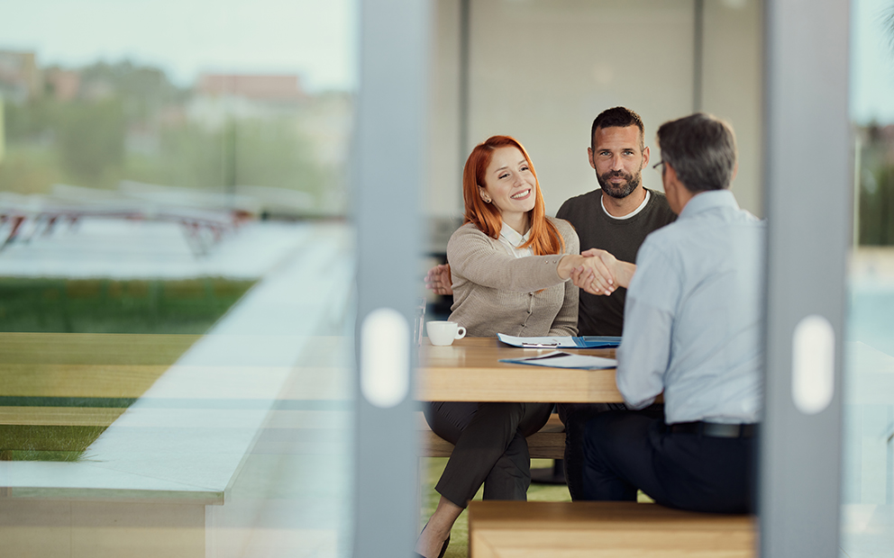 Couple shaking hands with advisor