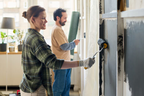 Couple painting walls at home together