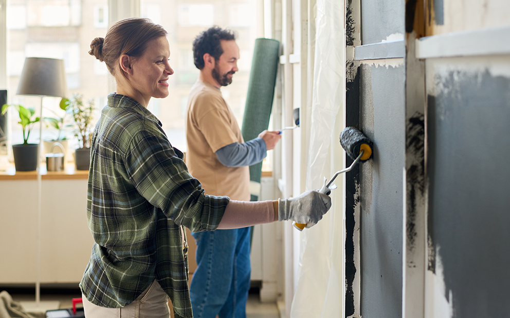 Couple painting walls at home together