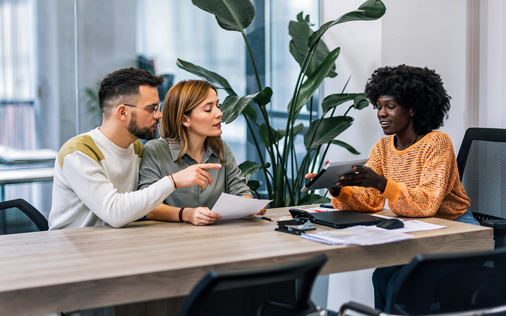 Couple discussing with advisor in office