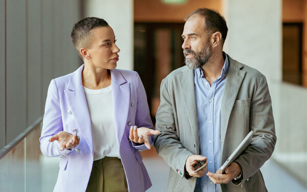Man and woman speaking to each other in office