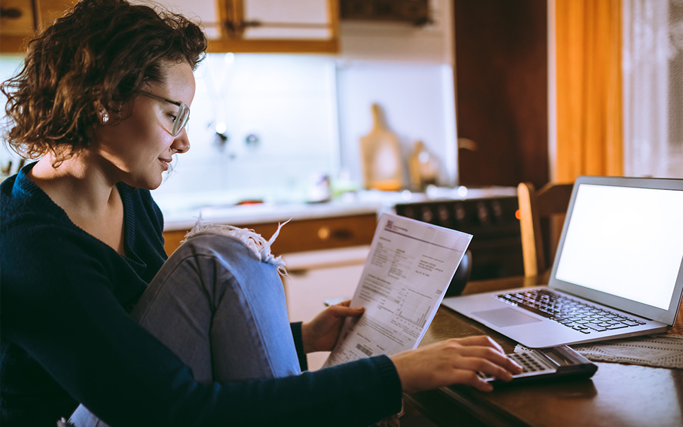 Woman reviewing documents while sitting at home kitchen