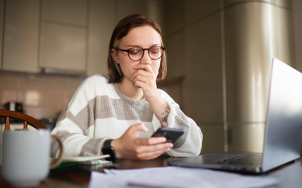 Woman researching information at home on her cell phone