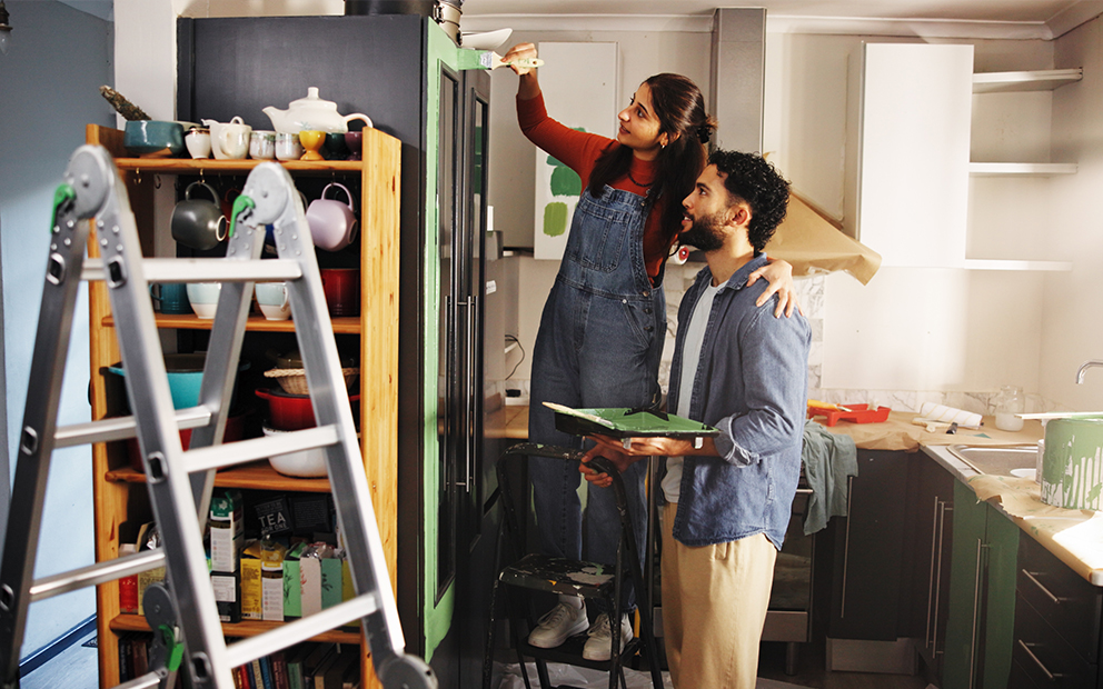 Man and woman painting kitchen at home