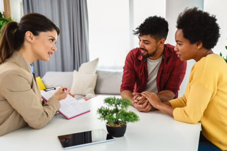 Young couple speaking with mortgage banker