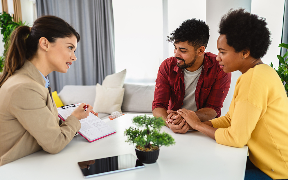 Young couple speaking with mortgage banker
