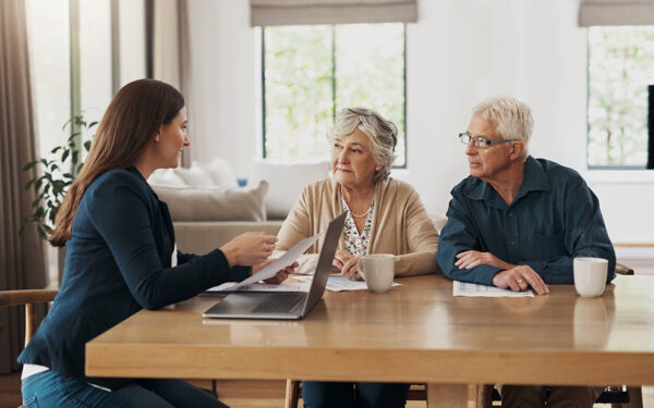 Older couple speaking with advisor at home
