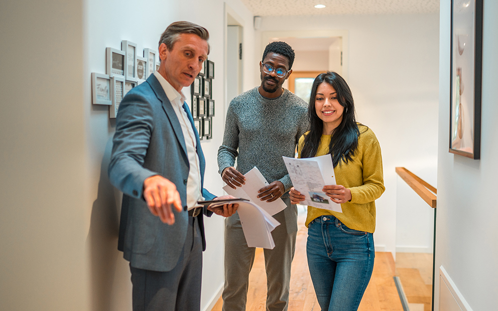 Young couple touring home with realtor