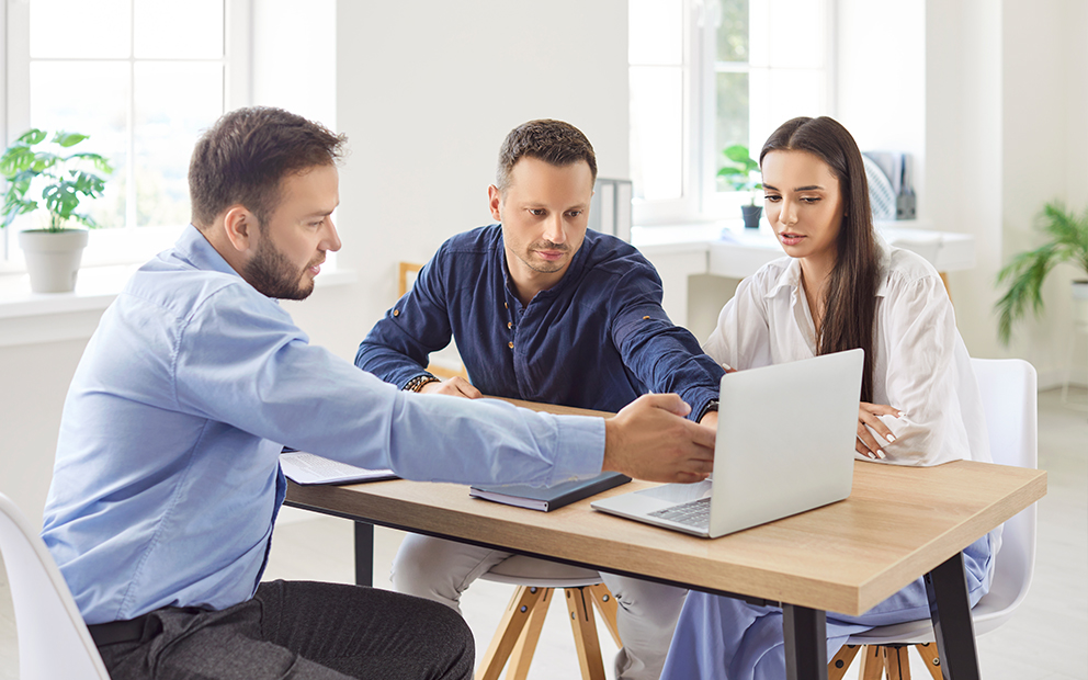 Young couple speaking with advisor at home