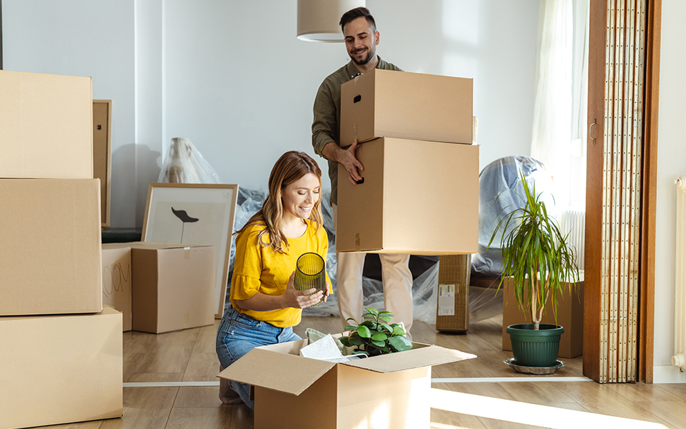 Happy mand and woman couple packing up belongings in home