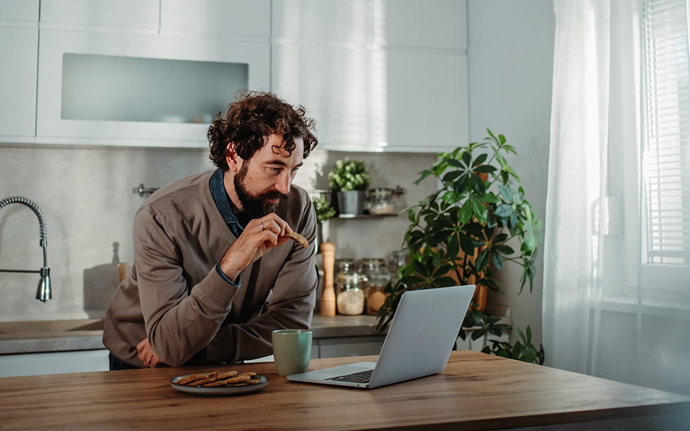 Man researching on laptop while in home kitchen