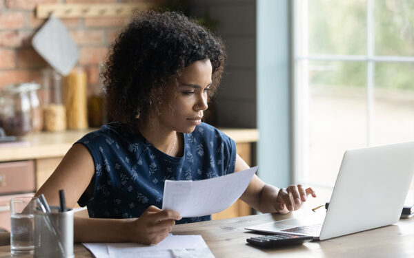 Woman researching info and finances on laptop while sitting at home