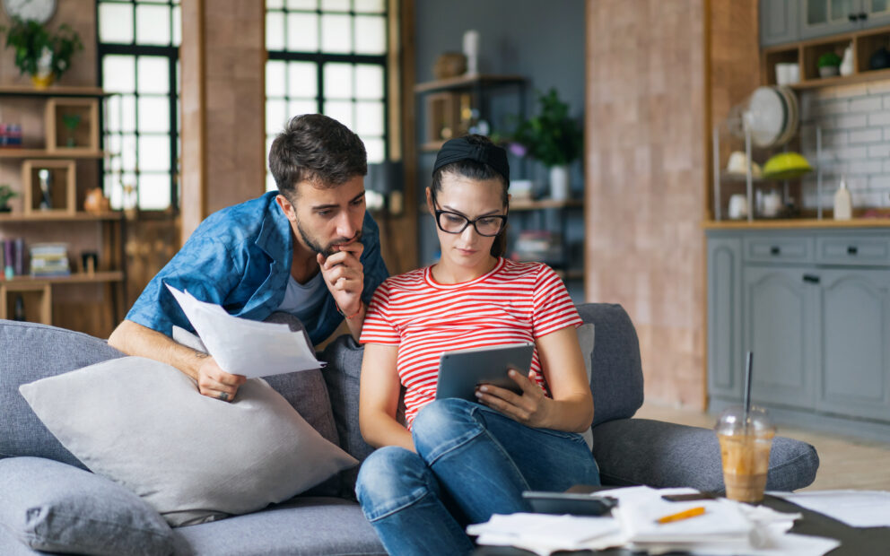 Couple at home looking over documents together and discussing paying extra on mortgage